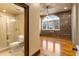 Modern bathroom featuring a glass-enclosed shower and view to open floor plan with brick and windows at 3180 Mathieson Ne Dr # 1401, Atlanta, GA 30305