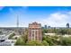 Aerial view of a luxurious brick condo building, surrounded by lush greenery and city skyline at 3180 Mathieson Ne Dr # 1401, Atlanta, GA 30305
