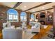 Bright living room featuring exposed brick, arched windows, wood beams, fireplace and hardwood floors at 3180 Mathieson Ne Dr # 1401, Atlanta, GA 30305