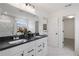 Bright bathroom featuring a double vanity with black countertop and modern fixtures at 352 Foxglove Way, Mcdonough, GA 30253