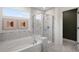 Elegant bathroom with a marble tiled shower and a luxurious soaking tub at 352 Foxglove Way, Mcdonough, GA 30253