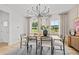 Bright dining room with modern chandelier, neutral walls, wooden table, and decorative artwork at 352 Foxglove Way, Mcdonough, GA 30253