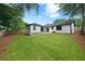 A spacious backyard shows a well-manicured lawn and freshly painted house, blending beauty and functionality at 4946 Lake Ridge Trail, Lilburn, GA 30047