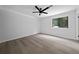 A bedroom space with light gray walls, a dark ceiling fan, wood-look flooring and a window with natural light at 4946 Lake Ridge Trail, Lilburn, GA 30047