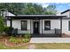 Charming front porch with black trim and a decorative front door for welcoming guests at 4946 Lake Ridge Trail, Lilburn, GA 30047