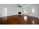 Inviting living room featuring gleaming hardwood floors, a fan, and a cozy white stone fireplace at 4946 Lake Ridge Trail, Lilburn, GA 30047
