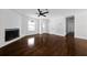 Bright living room featuring gleaming hardwood floors, a fan, and a cozy stone fireplace at 4946 Lake Ridge Trail, Lilburn, GA 30047