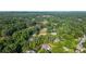 Scenic aerial shot of a neighborhood surrounded by mature trees, highlighting a pool, golf course, and community charm at 530 Old Cobblestone Dr, Atlanta, GA 30350