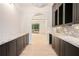 Butler's pantry featuring marble countertops, custom cabinetry, and an archway to the living room at 530 Old Cobblestone Dr, Atlanta, GA 30350