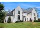 Two-story white brick home on a large lot with manicured lawn and mature trees at 530 Old Cobblestone Dr, Atlanta, GA 30350