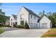 Two-story white brick home with a two-car garage and manicured lawn and driveway at 530 Old Cobblestone Dr, Atlanta, GA 30350