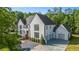 Beautiful white home with a three car garage surrounded by lush landscaping and a manicured lawn at 530 Old Cobblestone Dr, Atlanta, GA 30350