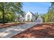 Elegant home featuring a manicured front lawn, a circular driveway, and a classic white exterior facade at 530 Old Cobblestone Dr, Atlanta, GA 30350