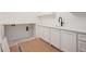 Bright laundry room with white cabinets, quartz countertops, and matte black faucet at 530 Old Cobblestone Dr, Atlanta, GA 30350