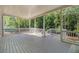 View of a screened patio with wood flooring, white railing, and forest views at 530 Old Cobblestone Dr, Atlanta, GA 30350