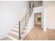 Staircase featuring metal railings, light wood accents, and natural light from a large window at 530 Old Cobblestone Dr, Atlanta, GA 30350