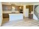 Spacious kitchen boasts modern appliances, a kitchen island, sleek cabinetry, and adjacent staircase at 62 Sheryl Way, Loganville, GA 30052