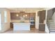 Well-designed kitchen features sleek cabinetry, an island, stainless steel appliances, and nearby stairs at 62 Sheryl Way, Loganville, GA 30052
