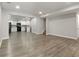 Open basement, flowing into the kitchen with wood-look floors and neutral paint at 829 Castlebottom Dr, Lawrenceville, GA 30045