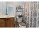 Functional bathroom with a vanity, toilet, and shower with a patterned curtain, and shelving for storage at 829 Castlebottom Dr, Lawrenceville, GA 30045