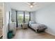 Cozy bedroom featuring a comfortable single bed, wood-look flooring, soft blue walls, and lots of natural light from the window at 829 Castlebottom Dr, Lawrenceville, GA 30045
