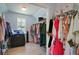 Spacious walk-in closet with ample storage and organization options, featuring shelves and hanging rods, and natural light from the window at 829 Castlebottom Dr, Lawrenceville, GA 30045
