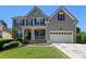 Charming two-story home featuring a well-maintained lawn, two-car garage, and inviting front porch at 829 Castlebottom Dr, Lawrenceville, GA 30045