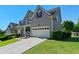 Side view of a two-story home with a well-manicured lawn and attached two-car garage at 829 Castlebottom Dr, Lawrenceville, GA 30045