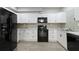 Modern kitchen with sleek, black appliances, white cabinets, and wood-look flooring at 829 Castlebottom Dr, Lawrenceville, GA 30045