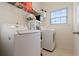 A clean laundry room with a washer, dryer, and wire shelving for storage at 829 Castlebottom Dr, Lawrenceville, GA 30045