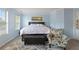 Spacious primary bedroom featuring tray ceiling, hardwood floors, sitting area, and windows at 829 Castlebottom Dr, Lawrenceville, GA 30045