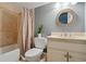 Well-lit bathroom featuring a shower-tub combo, vanity, and decorative mirror at 1070 Standard Ne Dr, Brookhaven, GA 30319