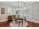 Dining room showcasing a modern chandelier, round glass table, and shuttered windows at 1070 Standard Ne Dr, Brookhaven, GA 30319