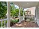 Charming front porch with brick floor, white columns, and views of the landscaped front yard at 1070 Standard Ne Dr, Brookhaven, GA 30319