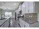 Modern kitchen with white cabinets, granite countertops, stainless steel appliances, and gray backsplash at 158 Bryon Ln, Acworth, GA 30102
