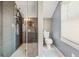 Modern bathroom with glass shower, toilet, and window with blinds, featuring tile flooring at 1649 Beecher Sw St, Atlanta, GA 30310
