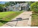 View of the home with a spacious concrete driveway, surrounded by lush greenery at 1649 Beecher Sw St, Atlanta, GA 30310