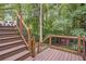 Spacious back deck with wooden staircase and railing overlooking the backyard shed and luscious green trees at 1867 N Creek Cir, Alpharetta, GA 30009