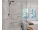 Elegant bathroom featuring glass enclosed shower, white marble tile, tub, and bright window at 1867 N Creek Cir, Alpharetta, GA 30009