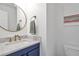 Bathroom featuring marble countertop, round mirror, and blue vanity at 1867 N Creek Cir, Alpharetta, GA 30009