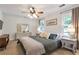 Inviting bedroom features a ceiling fan, two windows, neutral paint and bedding, and an attractive dresser at 1867 N Creek Cir, Alpharetta, GA 30009