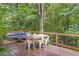 Outdoor deck featuring a seating area, table, and chairs surrounded by lush trees at 1867 N Creek Cir, Alpharetta, GA 30009