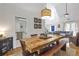 Bright dining area featuring a large wooden table, modern light fixture, and access to the living spaces at 1867 N Creek Cir, Alpharetta, GA 30009