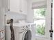 Bright laundry room with front loading washer and dryer and window to the backyard at 1867 N Creek Cir, Alpharetta, GA 30009