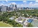 Expansive aerial view of community with a pool, tennis courts, and a lush green landscape against a city skyline at 281 15Th Ne St # 202, Atlanta, GA 30309