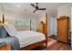 Bedroom with a four-poster bed, hardwood floors, shuttered windows, and ample closet space at 281 15Th Ne St # 202, Atlanta, GA 30309