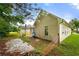View of the backyard with partial fencing and lawn, plus the exterior side of the home at 1394 Isleworth Cir, Atlanta, GA 30349