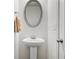 A clean bathroom featuring an oval mirror and pedestal sink at 147 Townview Dr, Woodstock, GA 30189