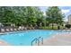 Enjoy the community pool, complete with lounge chairs, and shaded by mature trees, perfect for relaxing and soaking up the sun at 147 Townview Dr, Woodstock, GA 30189