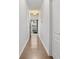 Bright hallway featuring hardwood floors, white walls, and contemporary lighting fixture at 147 Townview Dr, Woodstock, GA 30189